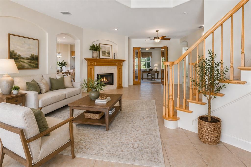 A living room features a fireplace, a staircase with wooden railings, and tile flooring — 601 VIENTO DE AVILA, TAMPA, FL