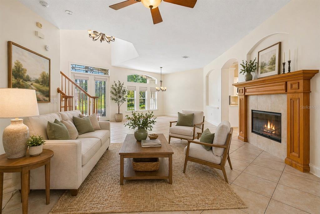 A living room features a fireplace, a sofa, two armchairs, and a staircase — 601 VIENTO DE AVILA, TAMPA, FL