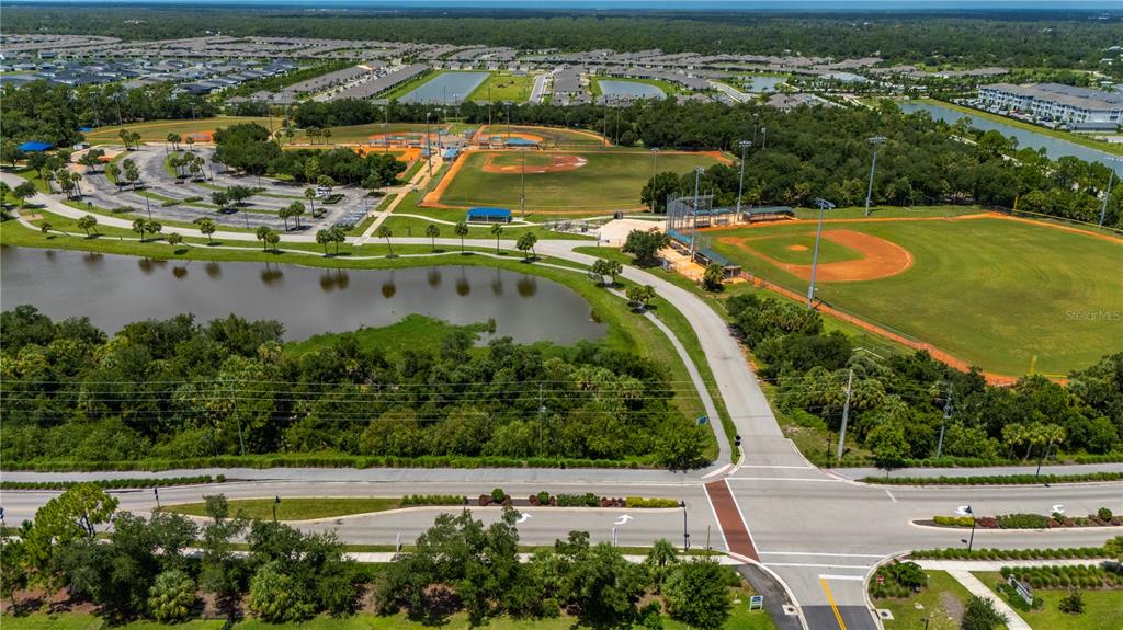 An aerial view shows a park with baseball fields, a pond, and surrounding residential neighborhoods — 1968 SUNSET PRESERVE WAY, PORT CHARLOTTE, FL