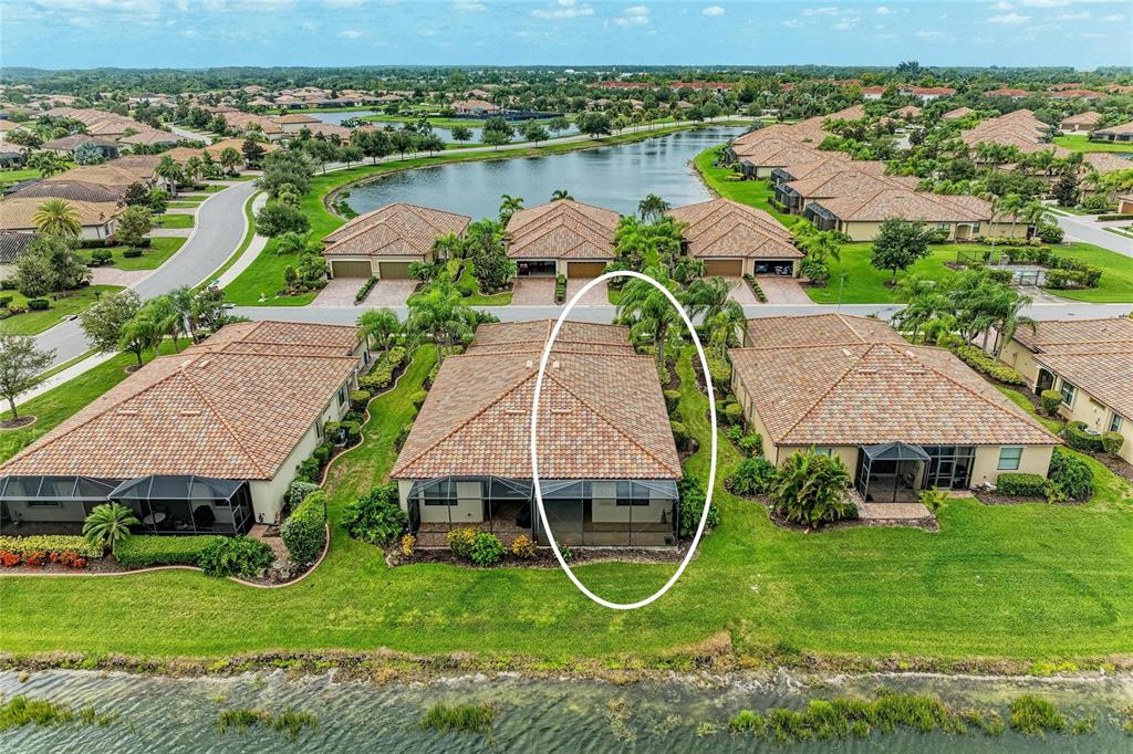 An aerial view shows a residential house with a tiled roof and a screened-in patio — 6623 CANDLESTICK DRIVE, BRADENTON, FL