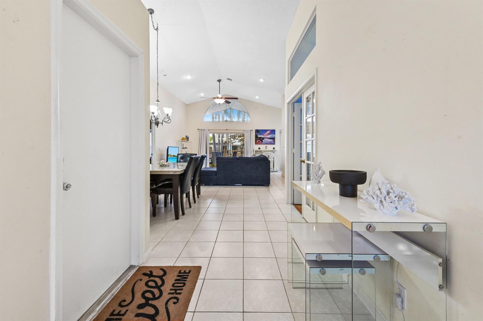 A tiled entryway leads into an open-concept living and dining area with vaulted ceilings — 2241 Soundings Court, FL 33413, FL