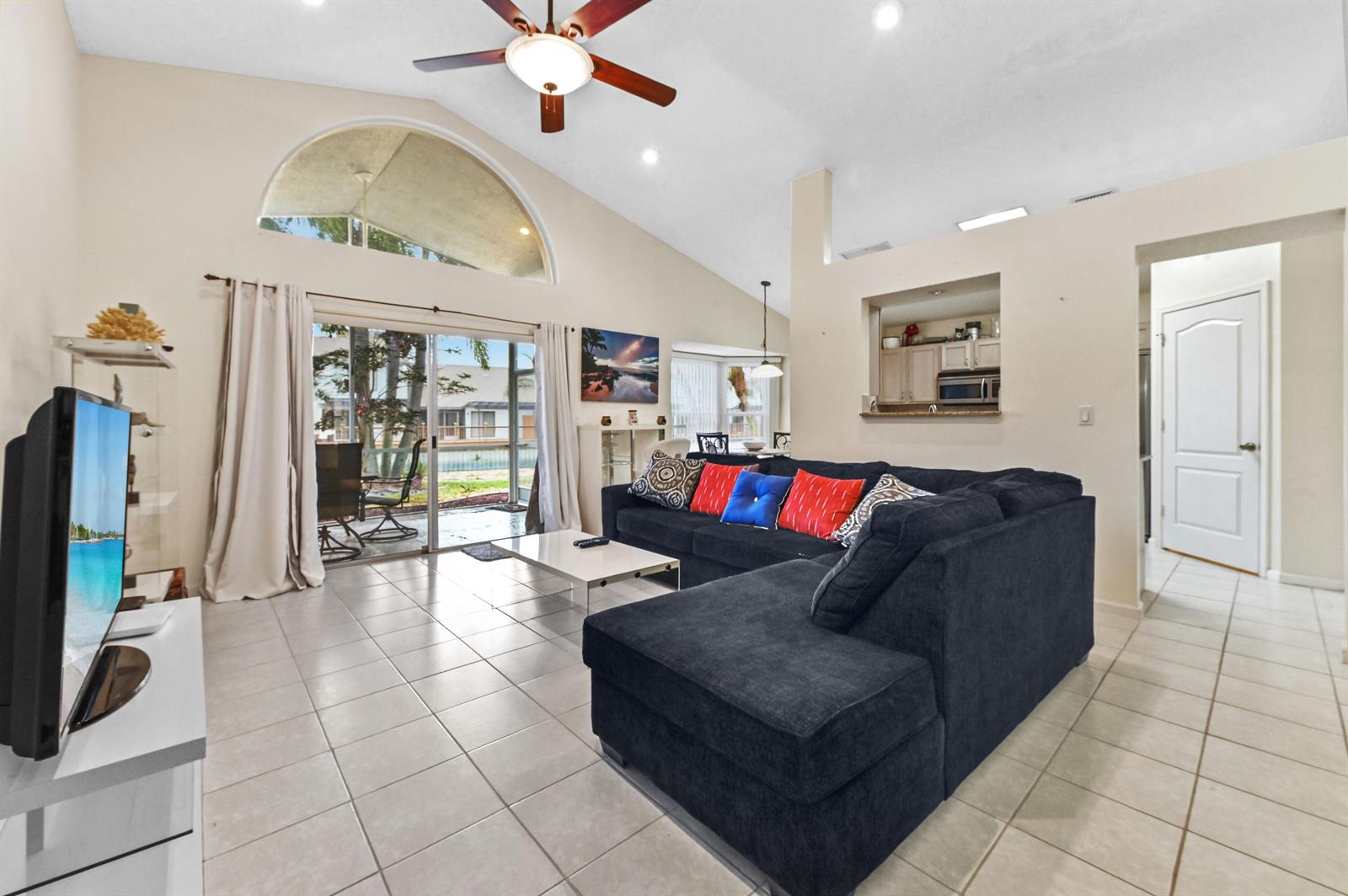 A living room with tile floors, a dark sectional sofa, and a vaulted ceiling — 2241 Soundings Court, FL 33413, FL
