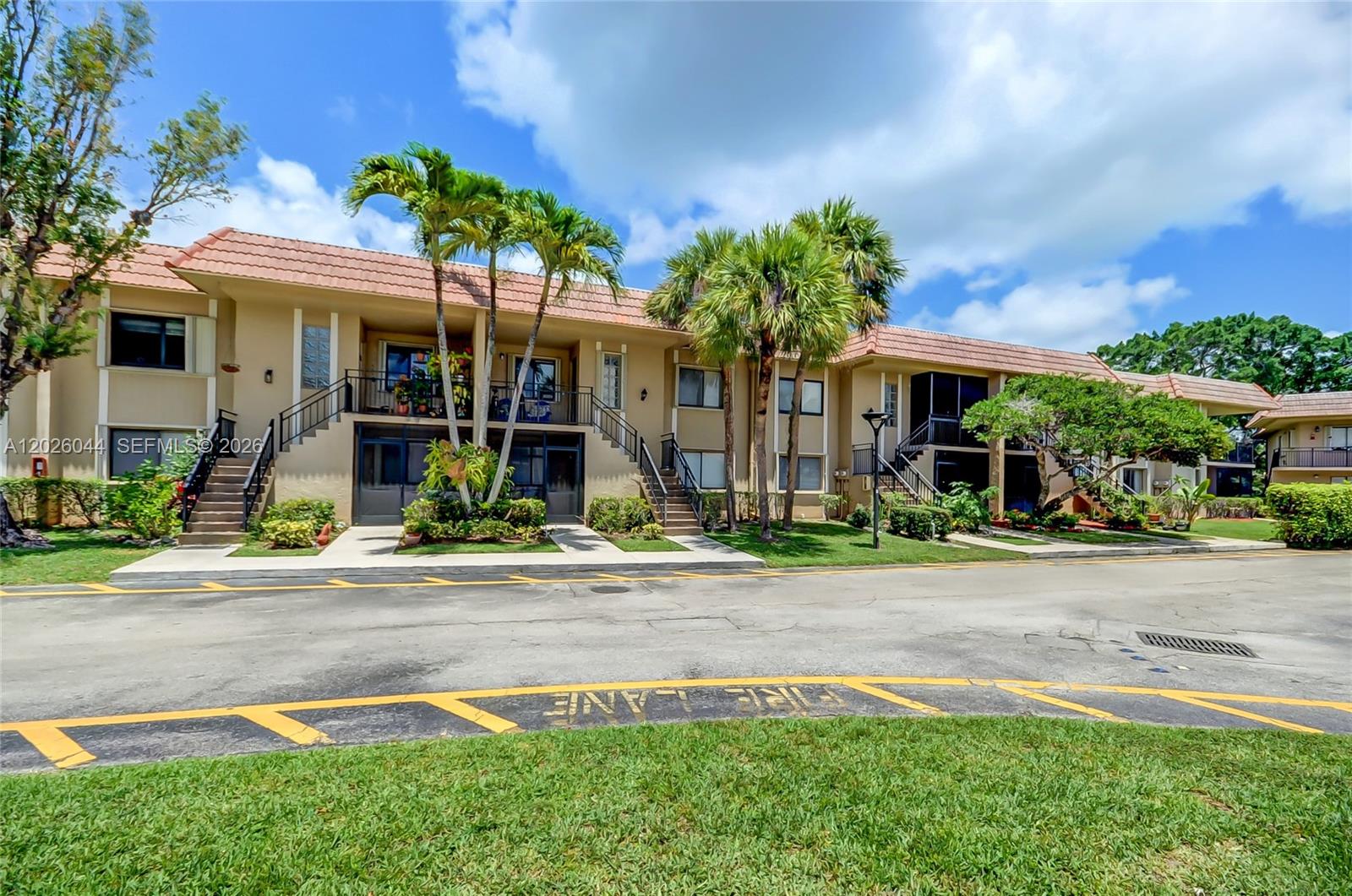 A two-story apartment building with tan stucco walls, tile roofs, and exterior staircases — 302 Lakeview Dr # 105, Weston FL 33326, WESTON, FL