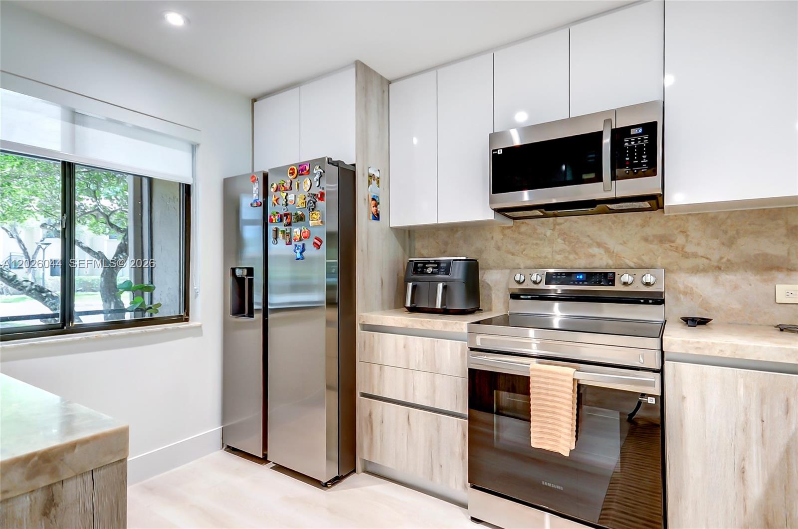 A kitchen features stainless steel appliances, light wood-grain cabinetry, and white upper cabinets — 302 Lakeview Dr # 105, Weston FL 33326, WESTON, FL