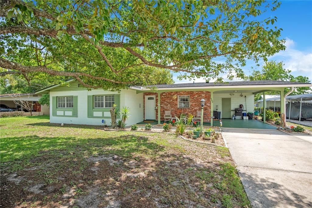 A single-story house with a brick facade, green trim, and an attached carport — 309 VIHLEN ROAD, SANFORD, FL