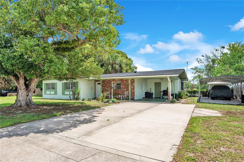 A single-story house with a brick facade, a covered porch, and a large front tree — 309 VIHLEN ROAD, SANFORD, FL