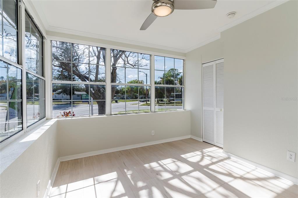 A sunroom with light wood flooring, large windows, a ceiling fan, and a white closet — 6699 78TH AVENUE N, PINELLAS PARK, FL