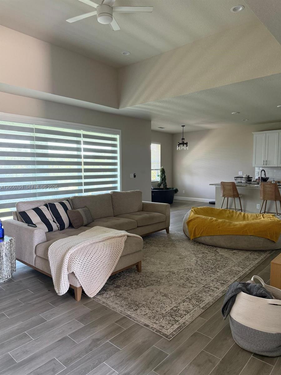A living room features a beige sectional sofa, a large area rug, and an open kitchen — 368 NEIGHBORLY RD, La Belle FL 33935, LA BELLE, FL