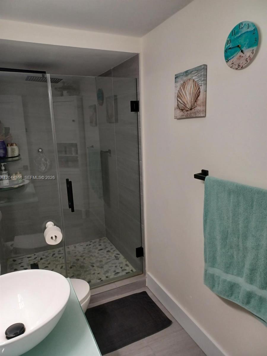 A bathroom features a glass-enclosed shower, a vessel sink, and coastal-themed wall decor — 1600 S Ocean Dr # 12F, Hollywood FL 33019, HOLLYWOOD, FL
