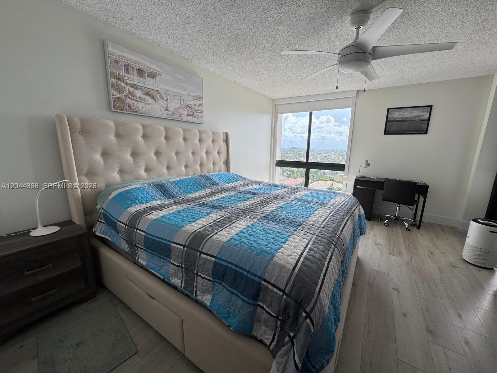 A bedroom features a tufted headboard bed, a desk, and a window with a view — 1600 S Ocean Dr # 12F, Hollywood FL 33019, HOLLYWOOD, FL