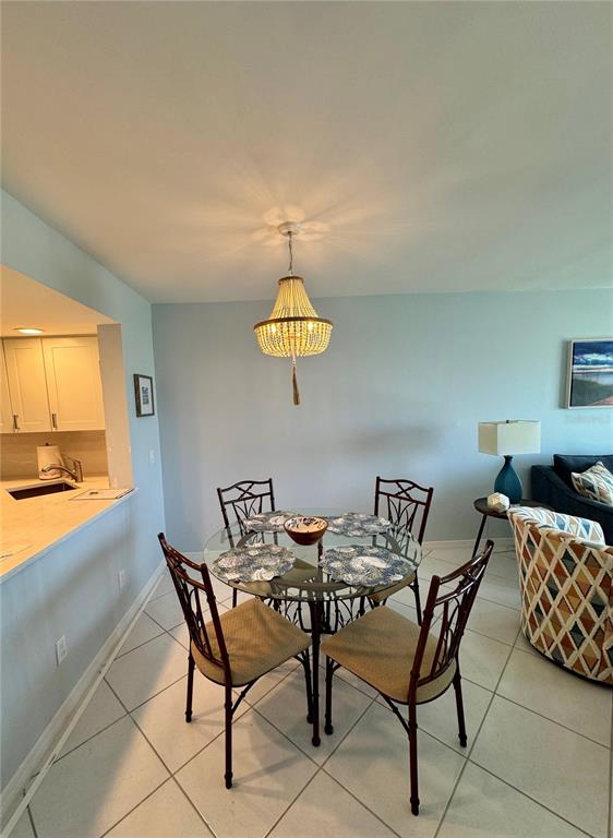 A dining area features a glass-topped table, four metal chairs, and a beaded chandelier — 2089 GULF OF MEXICO DRIVE UNIT G1-108, LONGBOAT KEY, FL
