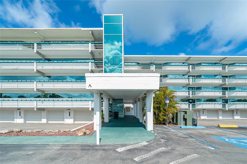 A multi-story building exterior features a covered entrance marked with an A and balconies — 1460 S MCCALL ROAD UNIT E3, ENGLEWOOD, FL