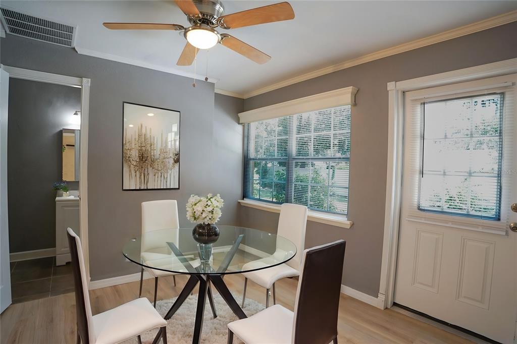 A dining area features a glass table, four chairs, a ceiling fan, and gray walls — 916 VERMONT AVENUE, ST CLOUD, FL
