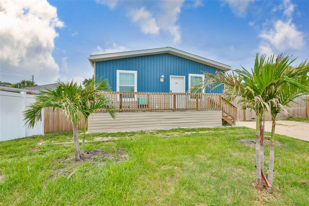 A blue mobile home with a wooden deck and two palm trees in the yard — 1169 8TH AVENUE NE, LARGO, FL