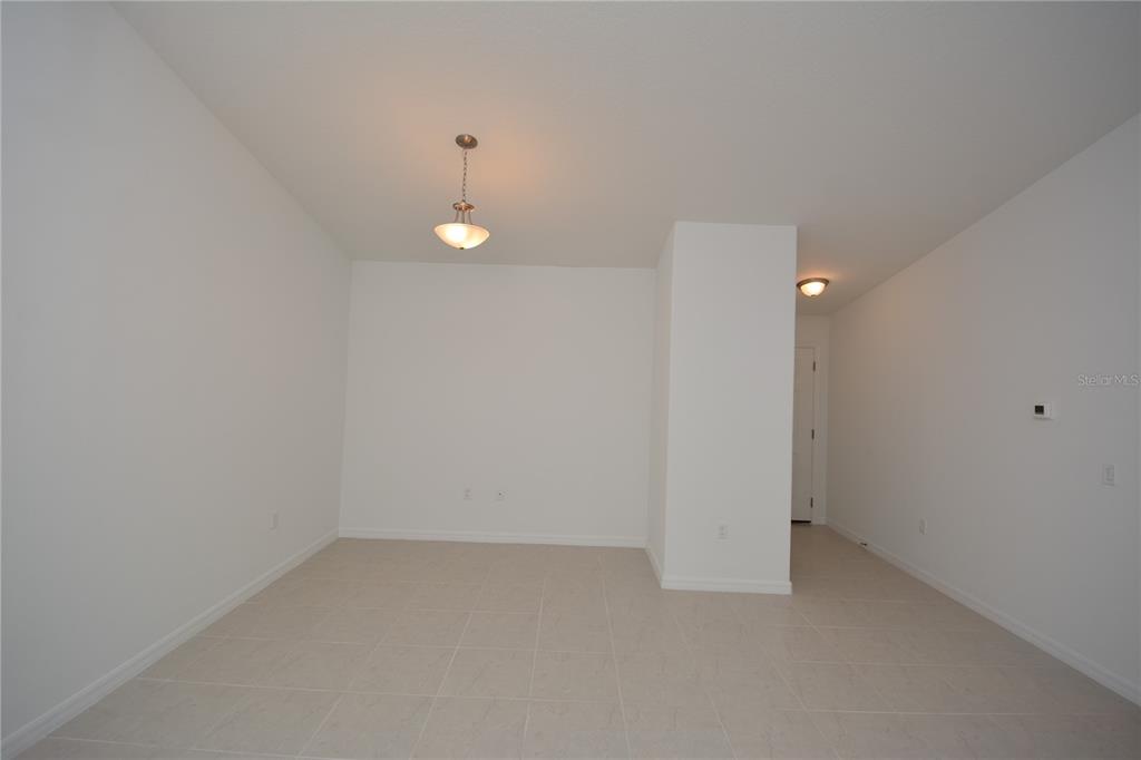An empty room with white walls, tile flooring, and two light fixtures — 31 ZOELLER COURT, PALM COAST, FL