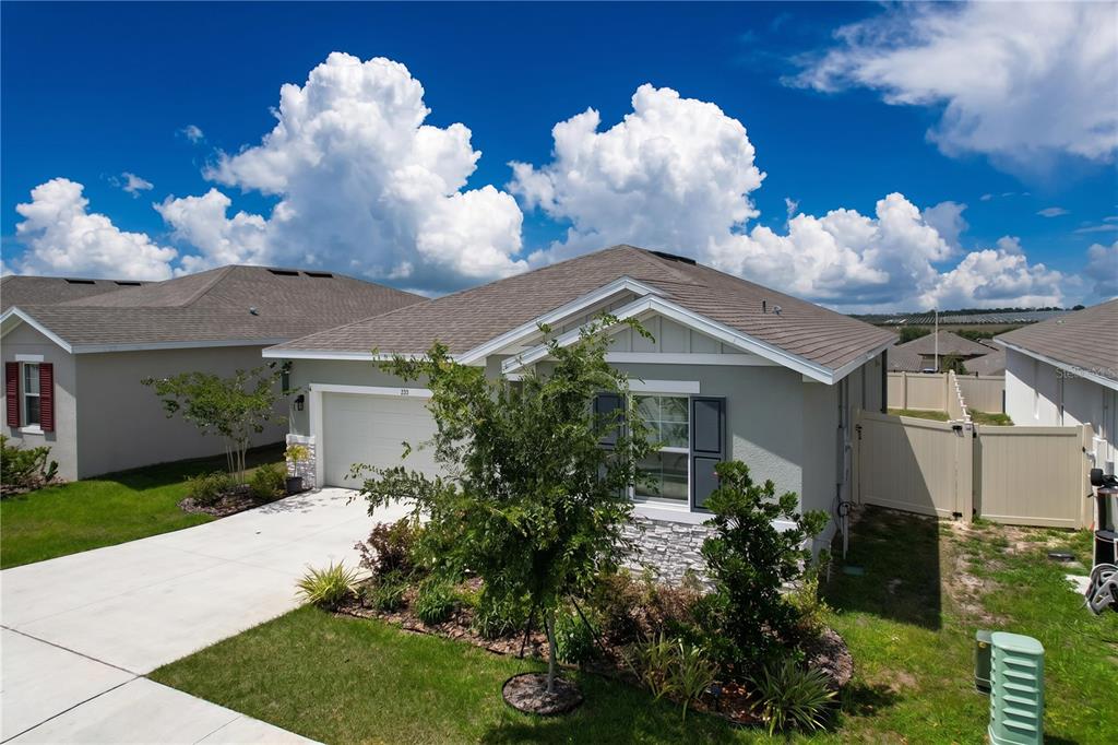 A light gray single-story house with a two-car garage and a landscaped front yard — 858 BALLANTYNE DRIVE, LAKE WALES, FL