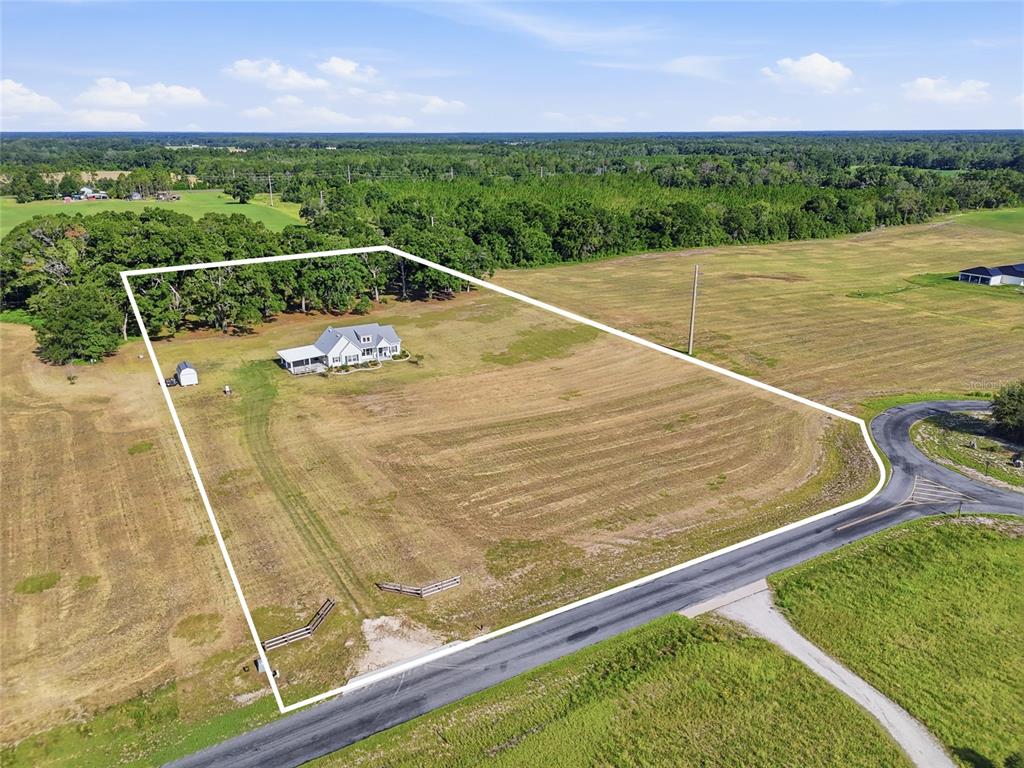 An aerial view shows a house and shed on a large, fenced-in rural lot — 3705 NW 31ST AVENUE, BELL, FL