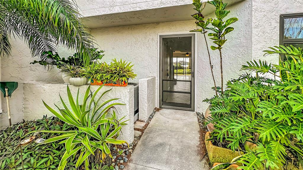 A concrete walkway leads to a glass storm door at the entrance of a home — 630 KILLARNEY BAY COURT UNIT 3, WINTER PARK, FL