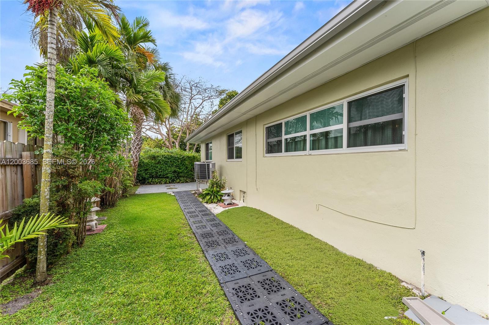 A side yard features a grassy lawn, a modular plastic walkway, and a beige house exterior — 501 Lawn Way, Miami Springs FL 33166, MIAMI SPRINGS, FL