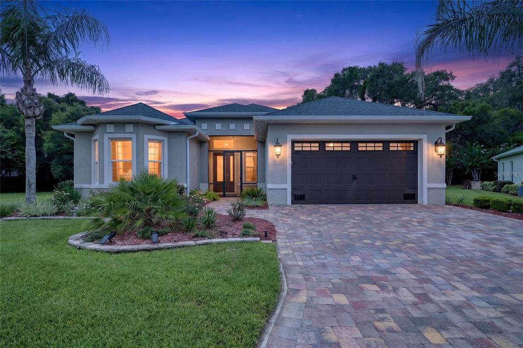 A single-story house with a paved driveway, a two-car garage, and a landscaped front yard — 10216 JULIA ISLES AVENUE, OXFORD, FL