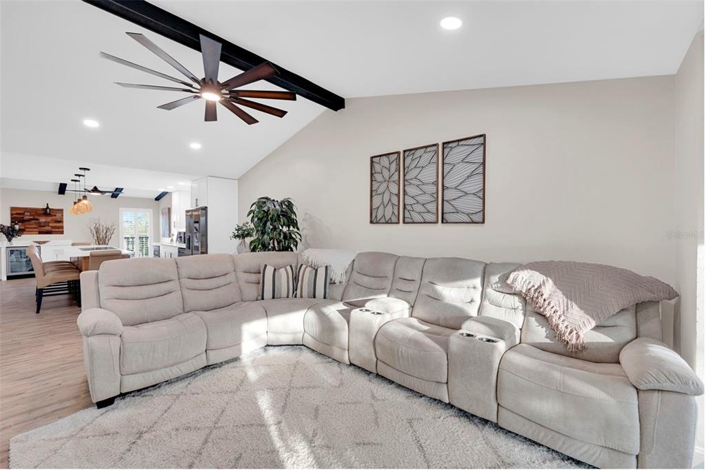 A living room features a large beige sectional sofa, a textured rug, and a ceiling fan — 15761 WINDWARD WAY CIRCLE UNIT 3302, FORT MYERS, FL