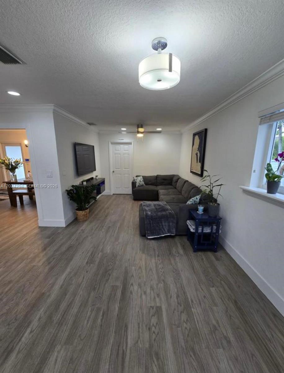 A living room features gray wood-look flooring, a sectional sofa, and a ceiling light fixture — 9591 SW 52nd Ter, Miami FL 33165, MIAMI, FL