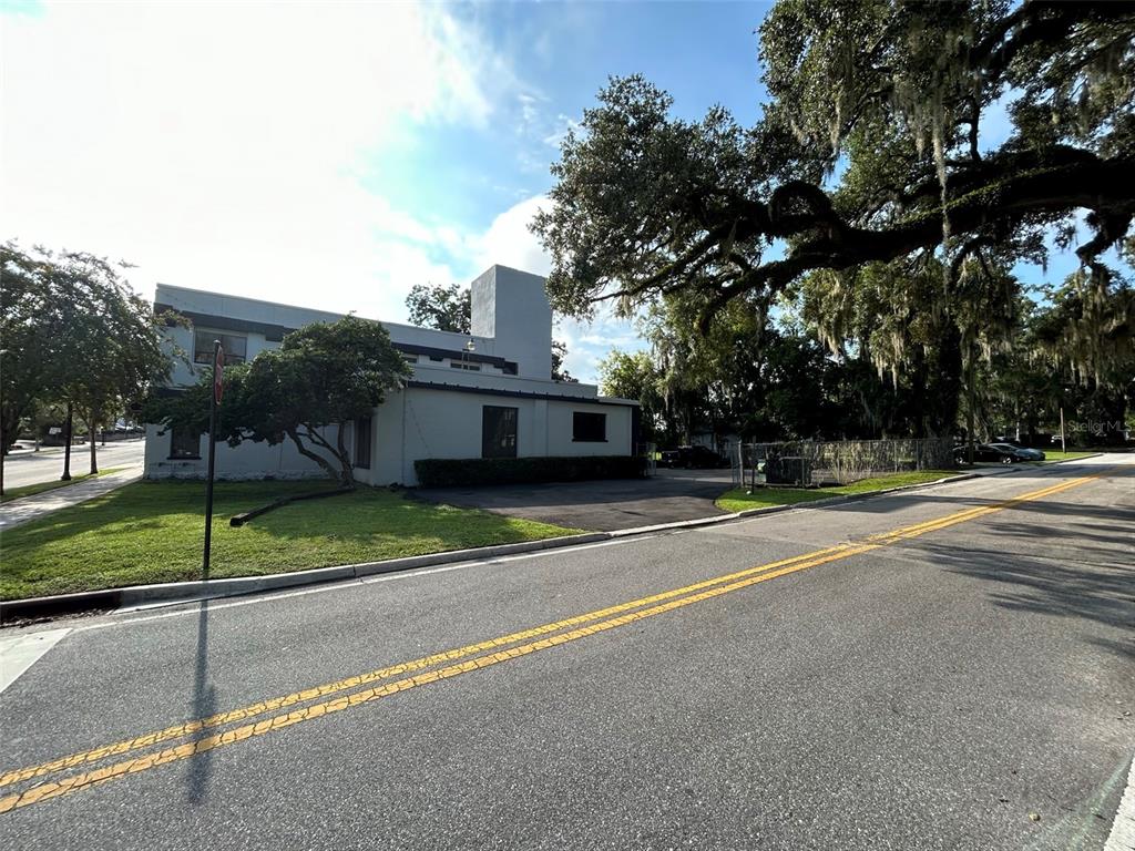 A two-story building with a flat roof and a paved parking area sits near a road — 118 SW FORT KING STREET, OCALA, FL