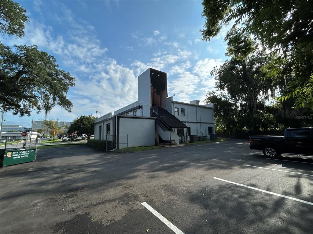 A two-story building with an exterior staircase and a parking lot in the foreground — 118 SW FORT KING STREET, OCALA, FL