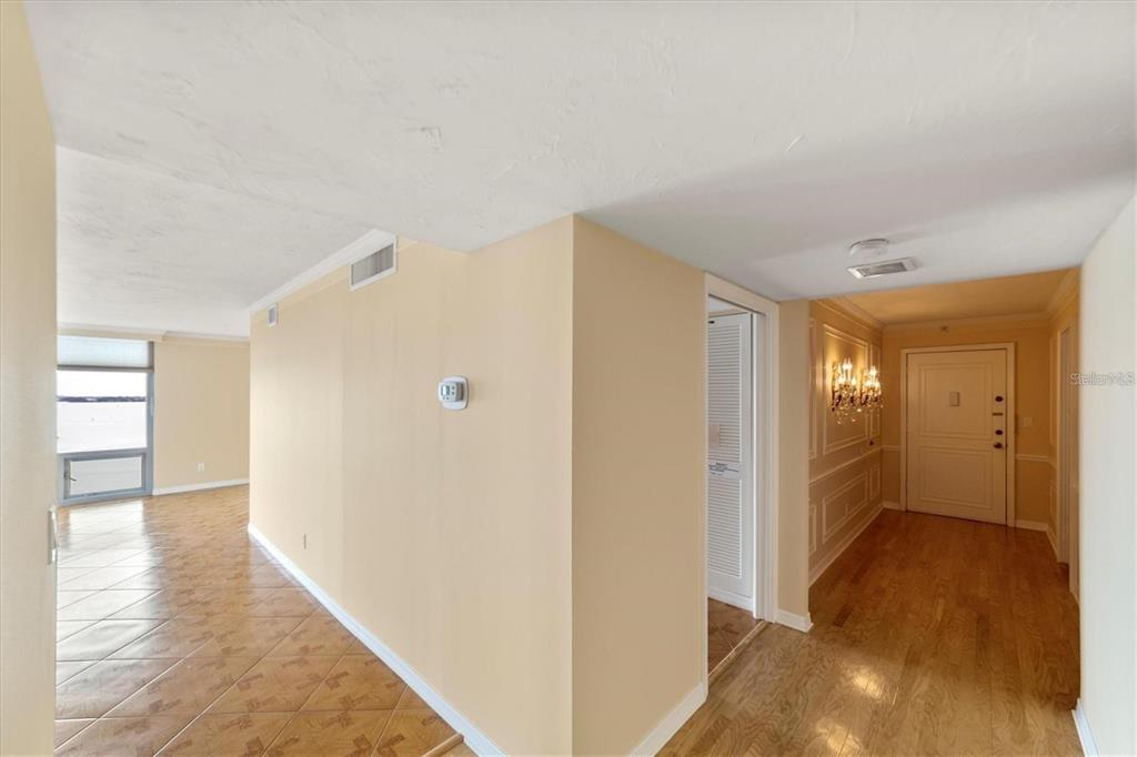 An interior view shows a hallway with tile flooring, a beige wall, and an entryway door — 1111 N GULFSTREAM AVENUE UNIT 16C, SARASOTA, FL