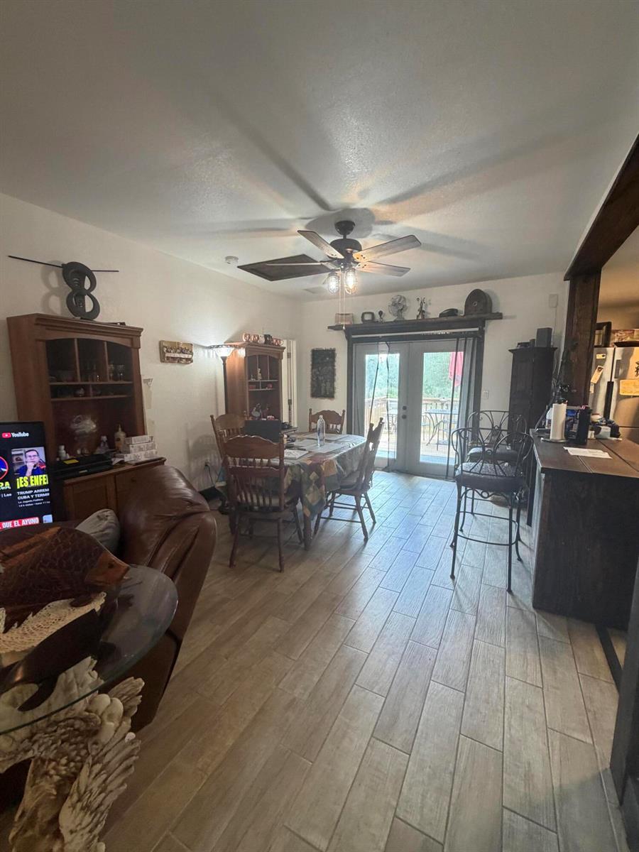 A dining area with wood-look tile floors, a ceiling fan, and French doors leading outside — 235 N Sendero Street, Clewiston FL 33440, CLEWISTON, FL