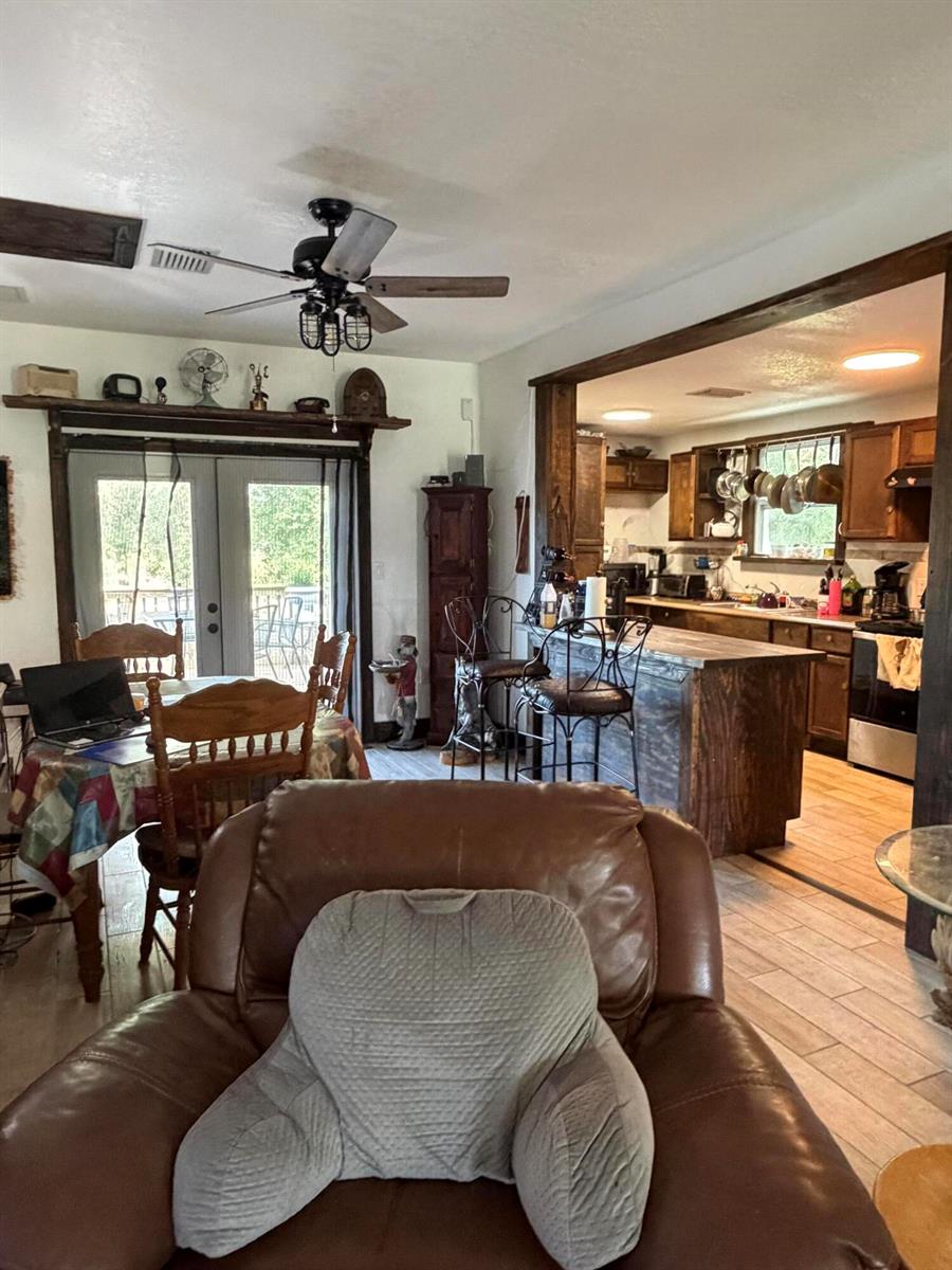 A living room with a leather recliner opens into a kitchen with wooden cabinetry — 235 N Sendero Street, Clewiston FL 33440, CLEWISTON, FL