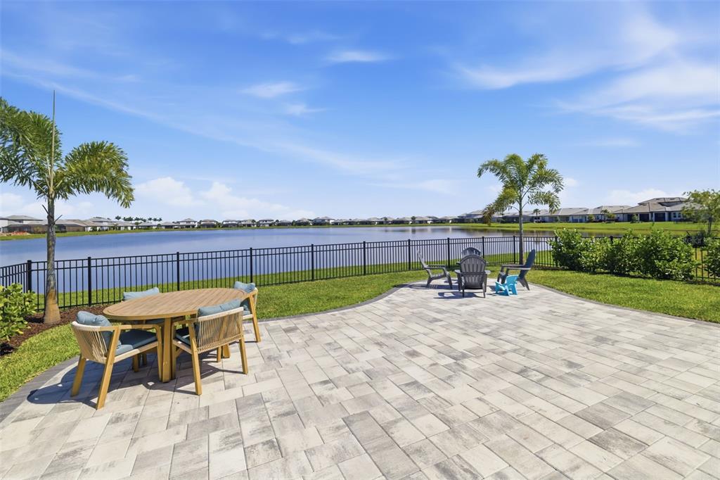 A paved patio with outdoor furniture overlooks a lake and a residential neighborhood — 17237 SAVORY MIST CIRCLE, BRADENTON, FL