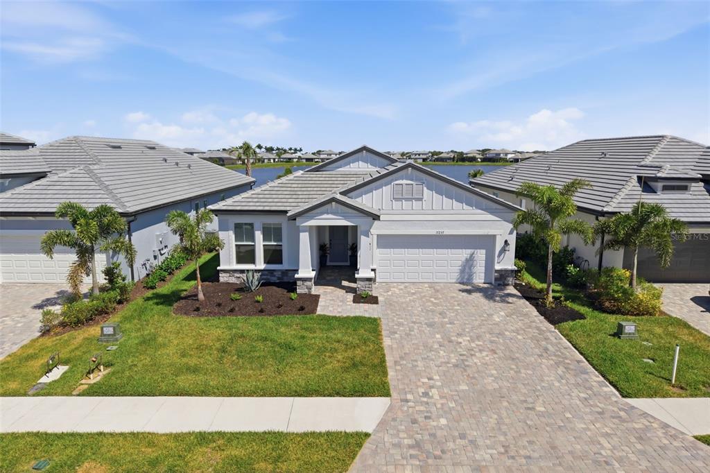 An aerial view of a single-story suburban house with a paved driveway and palm trees — 17237 SAVORY MIST CIRCLE, BRADENTON, FL