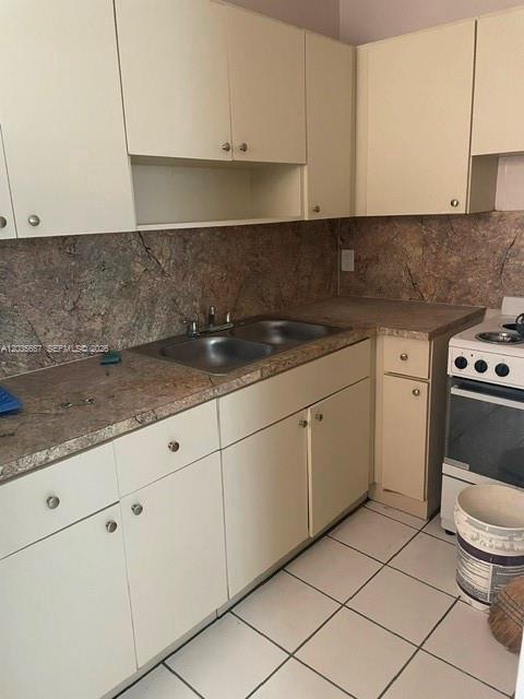A kitchen features white cabinets, a double sink, stone-look countertops, and a white stove — 2751 NW 46th St # 11, Miami FL 33142, MIAMI, FL