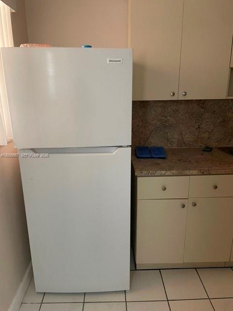 A white Frigidaire refrigerator stands next to beige kitchen cabinets and a laminate countertop — 2751 NW 46th St # 11, Miami FL 33142, MIAMI, FL