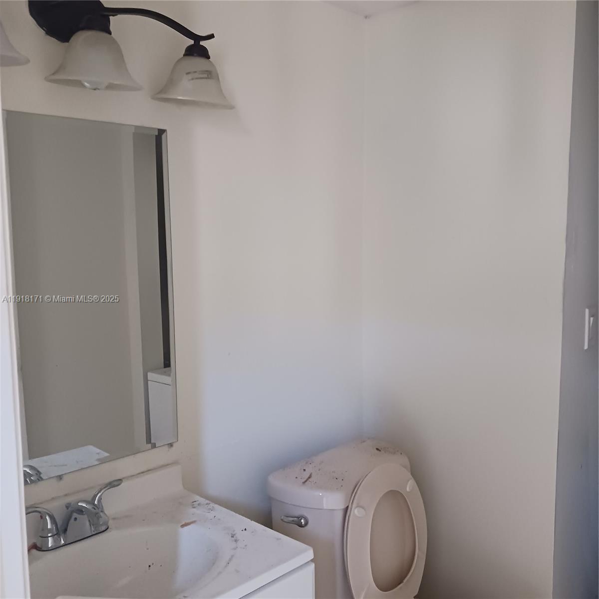 A bathroom features a vanity with a sink, a mirror, lighting, and a toilet — 2108 NW 59th Ter # A, Lauderhill FL 33313, LAUDERHILL, FL