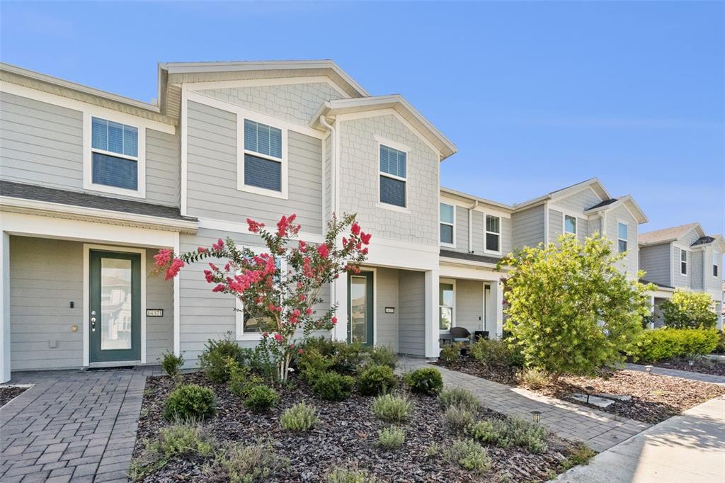 A row of light gray townhouses features green front doors and landscaped front yards — 14375 SAPELO BEACH DRIVE, ORLANDO, FL