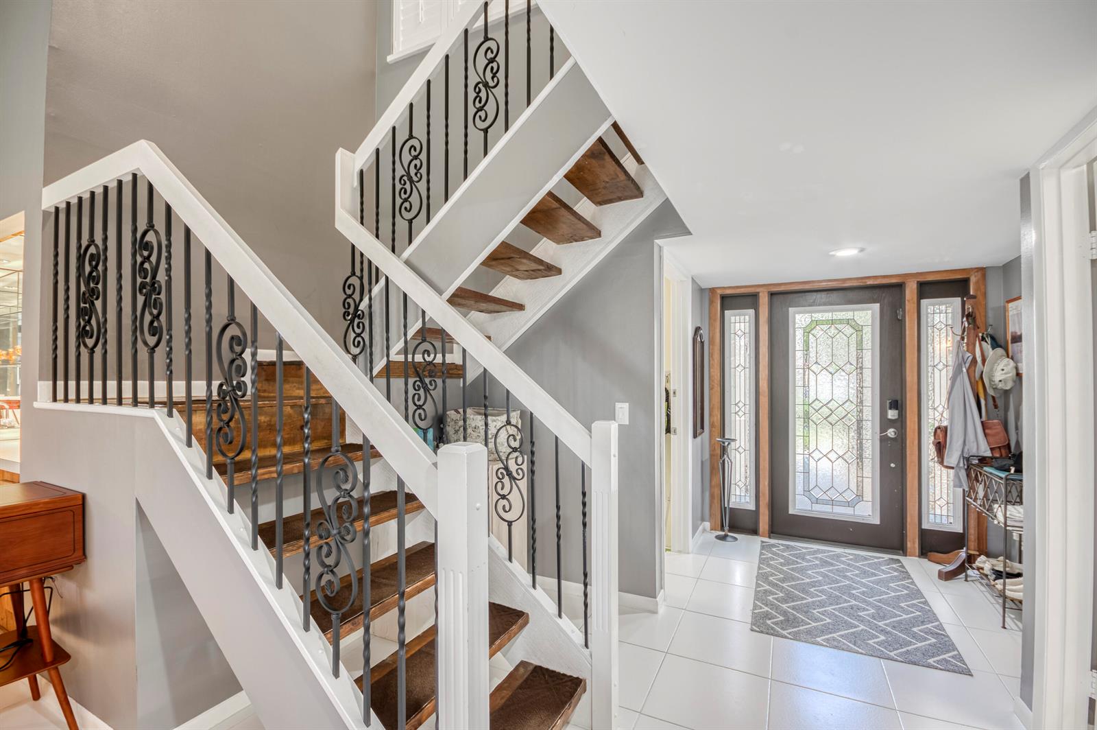 An entryway features a staircase with wood treads, decorative iron railings, and a glass-paneled door — 11135 Oakdale Road, Boynton Beach FL 33437, BOYNTON BEACH, FL