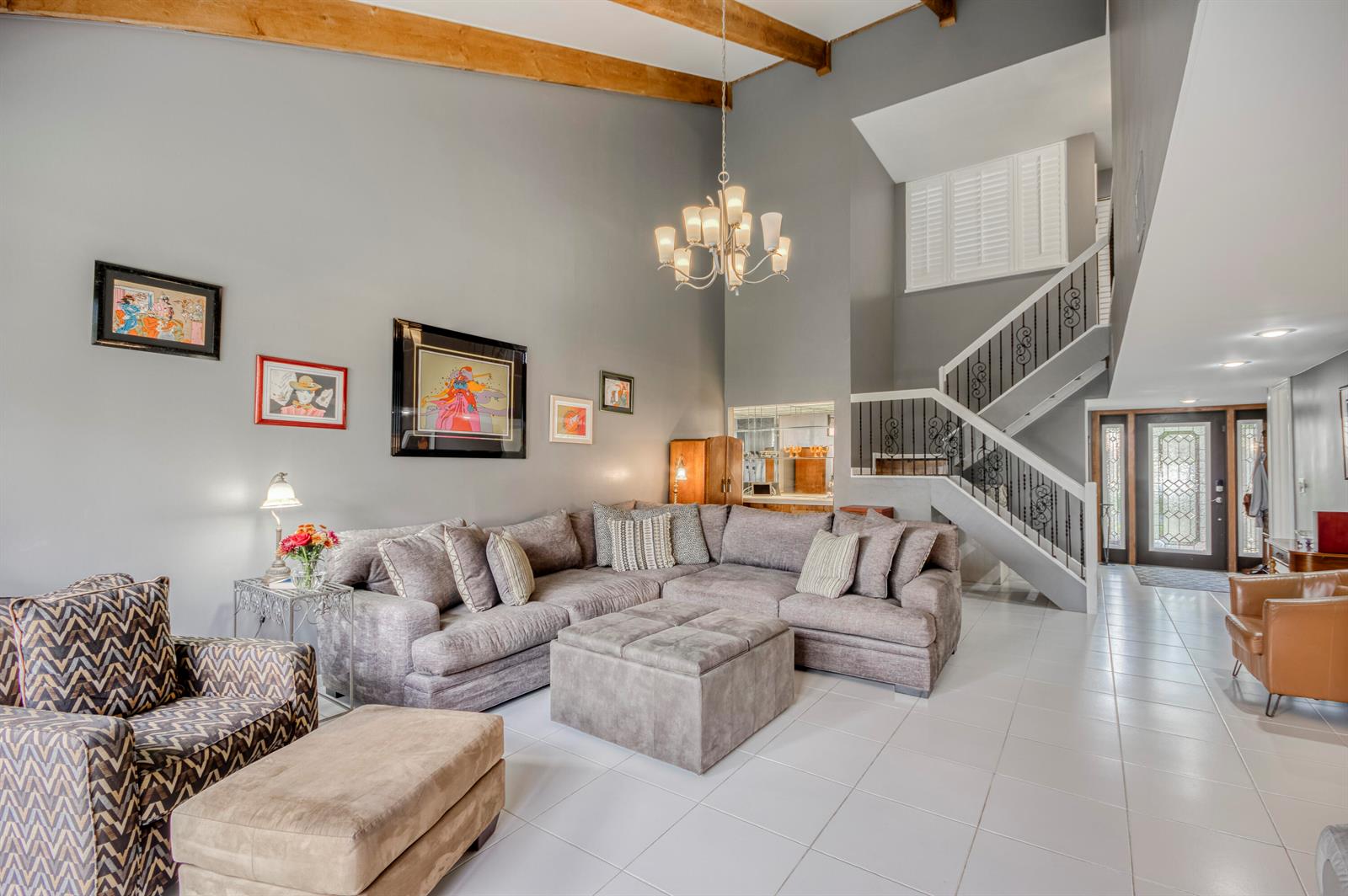 A living room features a sectional sofa, a staircase with iron railings, and vaulted ceilings — 11135 Oakdale Road, Boynton Beach FL 33437, BOYNTON BEACH, FL