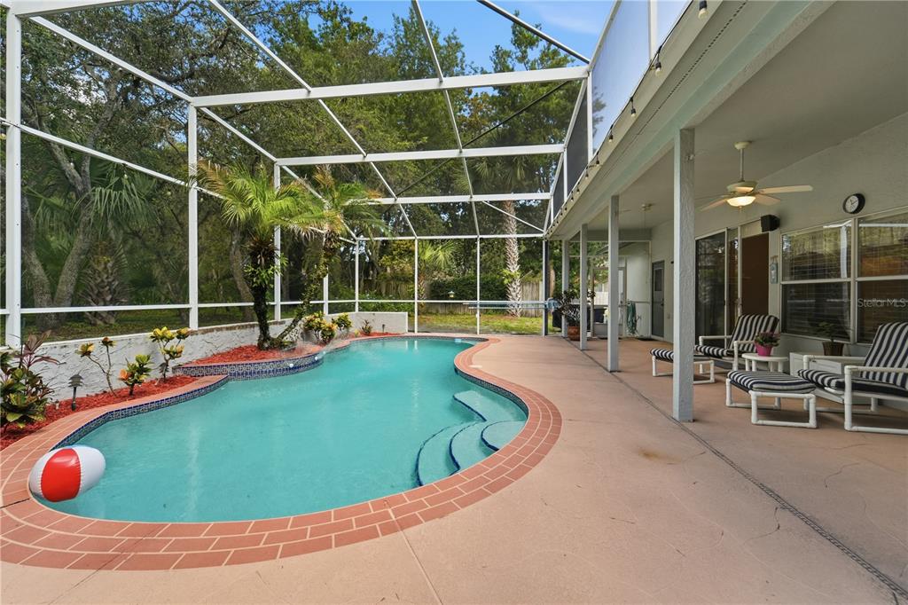 A screened-in swimming pool with a brick-trimmed deck and patio furniture under a covered lanai — 1053 OLD COVENTRY COURT, OVIEDO, FL
