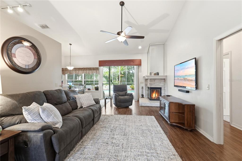 A living room features a gray sofa, a fireplace, a television, and a ceiling fan — 1053 OLD COVENTRY COURT, OVIEDO, FL