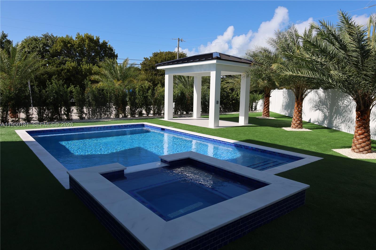 A backyard features a swimming pool, a raised spa, and a white gazebo on turf — 258 Caribbean Dr, Key Largo FL 33037, KEY LARGO, FL