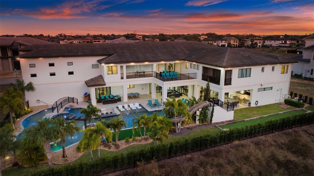 An aerial view of a large two-story house with a pool, waterslide, and backyard patio — 1148 GRAND TRAVERSE PARKWAY, REUNION, FL