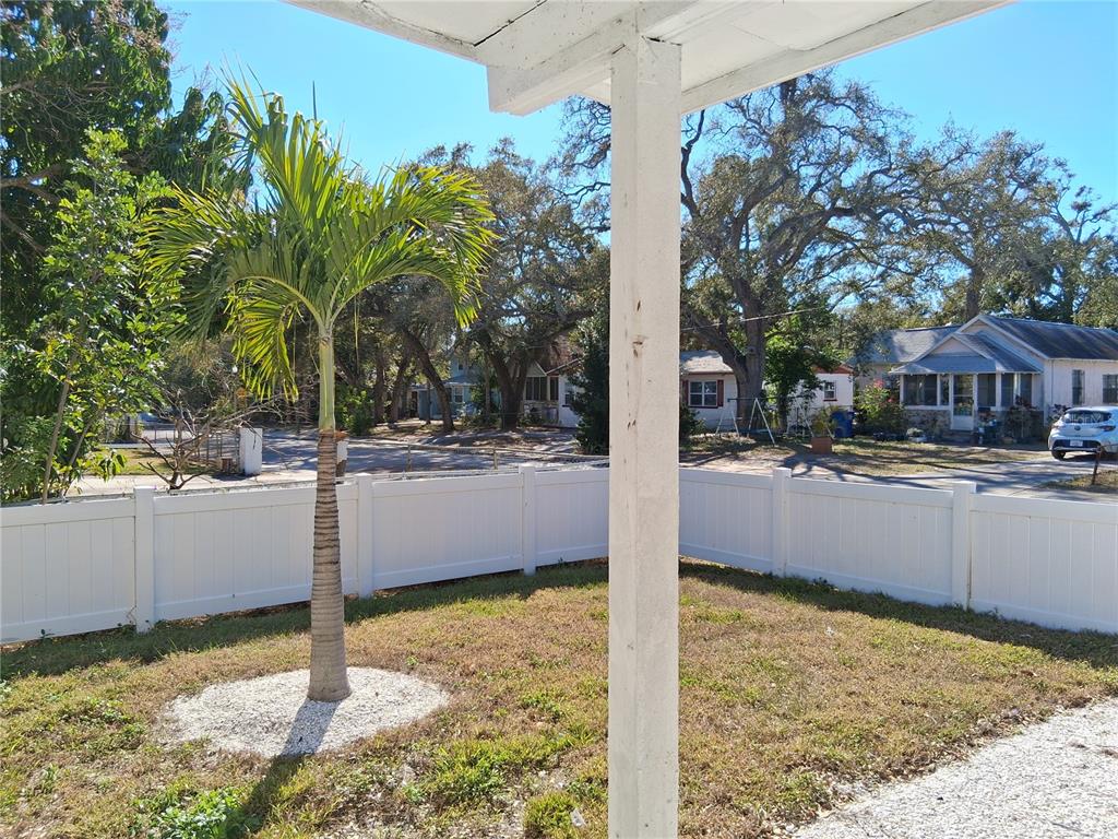 A view from a covered porch looking out at a yard with a palm tree — 2020 13TH STREET S, ST PETERSBURG, FL