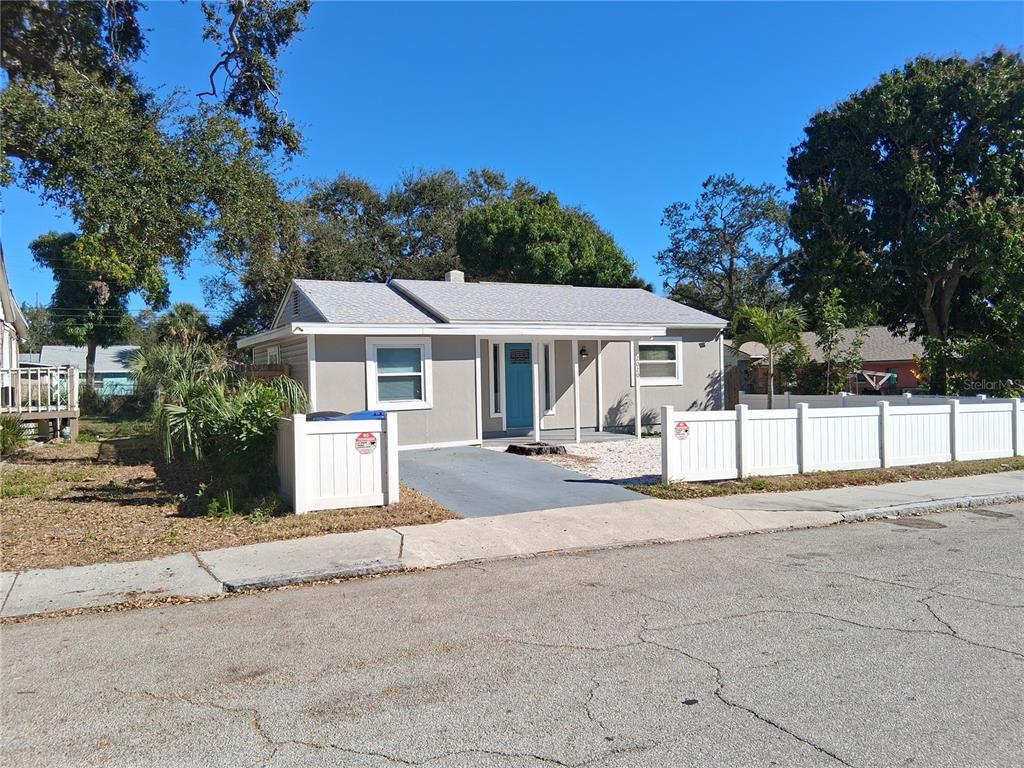 A single-story house with a gray exterior, a blue front door, and a white fence — 2020 13TH STREET S, ST PETERSBURG, FL