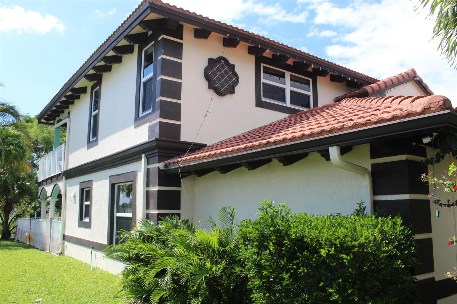 A two-story house with stucco walls, dark brown trim, and a red tile roof — 13847 Geranium Place, Wellington FL 33414, WELLINGTON, FL
