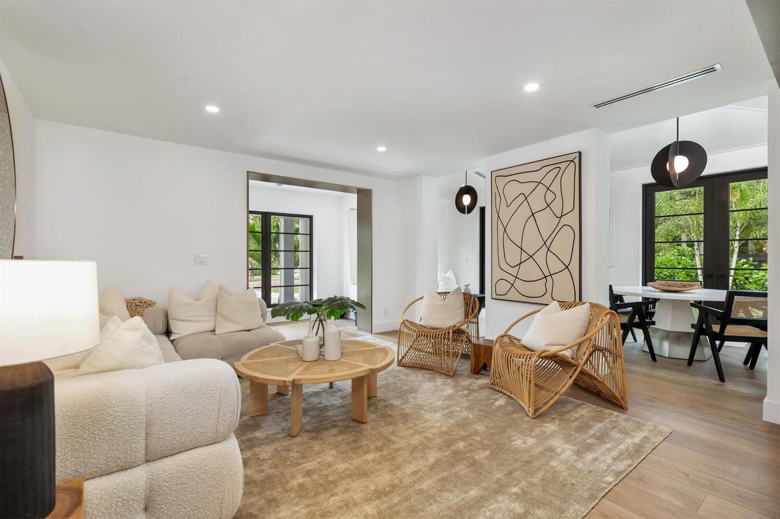 A bright entryway features a dark wooden bench, a modern mirror, and light hardwood floors — 263 Alhambra Place, West Palm Beach FL 33405, WEST PALM BEACH, FL