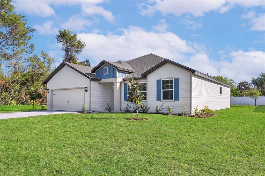 A single-story house with white siding, blue shutters, and a two-car garage — 3 FIELDING LANE, PALM COAST, FL