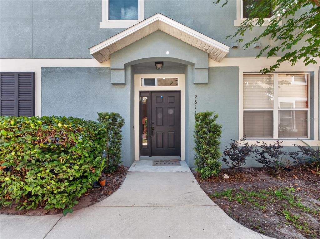 A concrete walkway leads to the front entrance of a blue stucco home — 2811 SAN JACINTO CIRCLE, SANFORD, FL