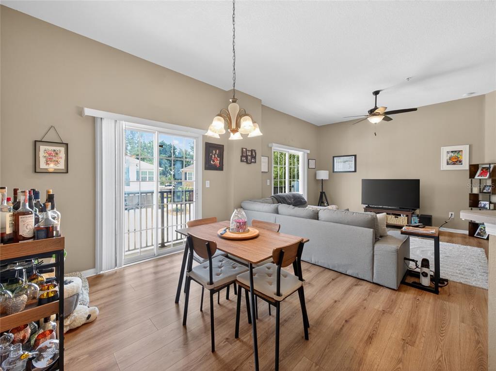 A dining area with a wooden table and chairs sits next to a living room — 2811 SAN JACINTO CIRCLE, SANFORD, FL